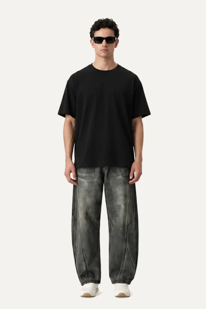 The model in the Baseline Tee in ink and washed grey Column jeans, standing square to the camera, arms at his sides.